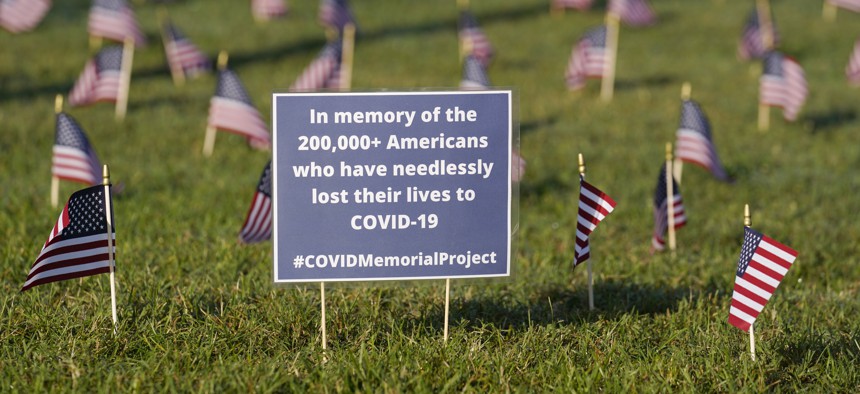 Activists from the COVID Memorial Project mark the deaths of 200,000 lives lost in the U.S. to COVID-19 after placing thousands of small American flags places on the grounds of the National Mall in Washington, D.C. on Sept. 22, 2020. (