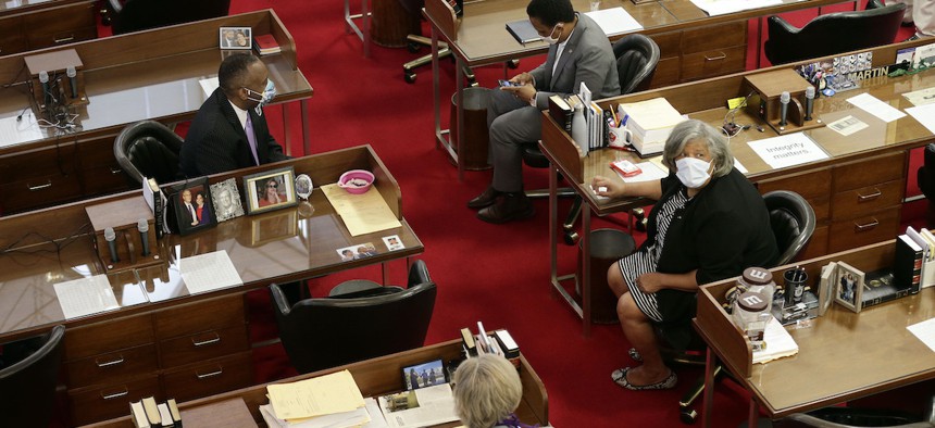 A limited number of lawmakers gather on the House floor as the North Carolina General Assembly opens a new session amid the current COVID-19 stay-at-home restrictions in Raleigh, N.C., Tuesday, April 28, 2020. (AP Photo/Gerry Broome)