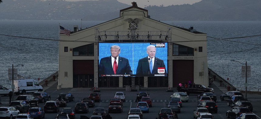 People watch from their vehicles as President Donald Trump, left, and Democratic presidential candidate former Vice President Joe Biden speak during a Presidential Debate Watch Party at Fort Mason Center in San Francisco, on Oct. 22, 2020.