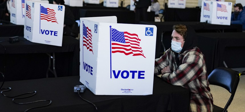 A voter casts his ballot during voting at a poling place inside Bankers Life Fieldhouse on Election Day in Indianapolis, Tuesday, Nov. 3, 2020.