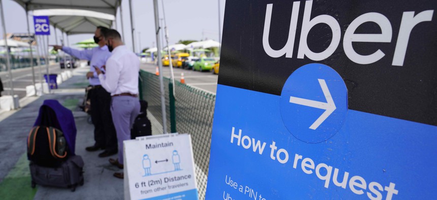 In this Aug. 20, 2020 photo travelers request an Uber ride at Los Angeles International Airport's LAX-it pick up terminal. Proposition 22 pitted the powerhouses of the so-called gig economy, including DoorDash, Postmates and Instacart, against labor union
