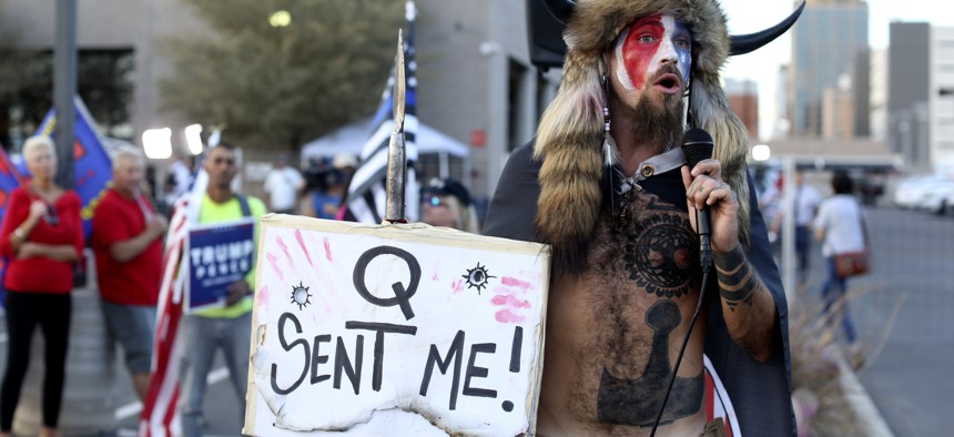 A Qanon believer speaks to a crowd of President Donald Trump supporters outside of the Maricopa County Recorder's Office where votes in the general election are being counted, in Phoenix, Thursday, Nov. 5, 2020.