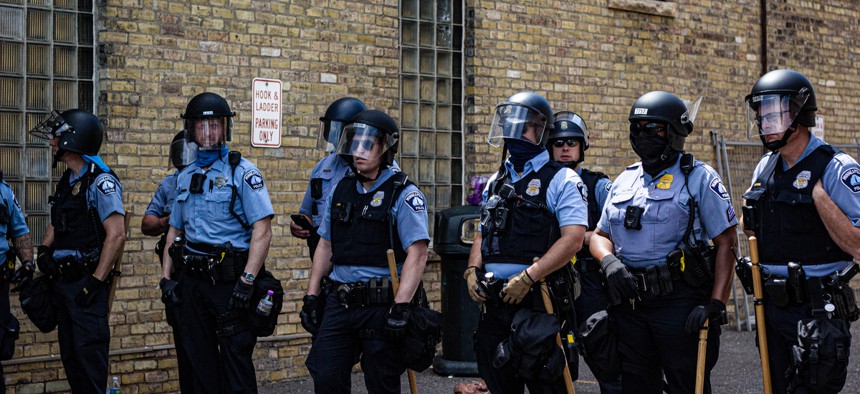 Minneapolis police stand near the Third Precinct in May. The department is under investigation by the state Human Rights Department.
