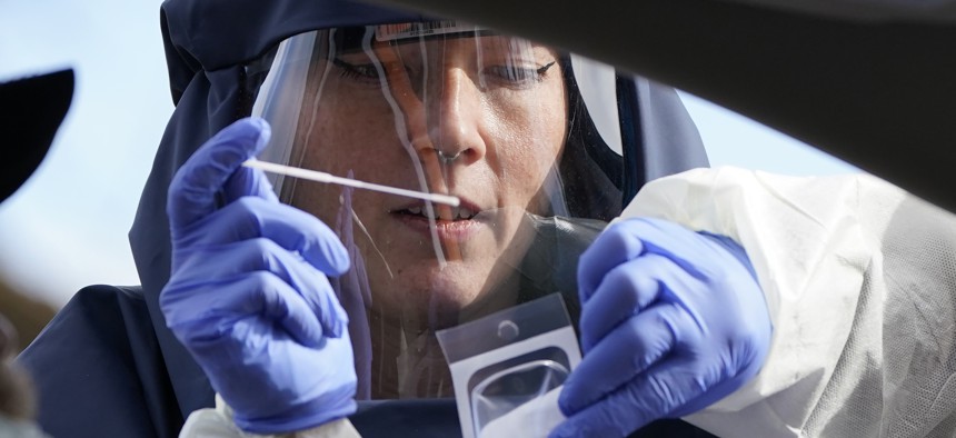 A Salt Lake County Health Department public health nurse performs a coronavirus test at the Salt Lake County Health Department Friday, Nov. 13, 2020, in Salt Lake City.