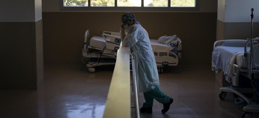 A respiratory therapist talks on the phone next to hospital beds while taking a break in the COVID-19 unit at Providence Holy Cross Medical Center in the Mission Hills section of Los Angeles, Thursday, Nov. 19, 2020.