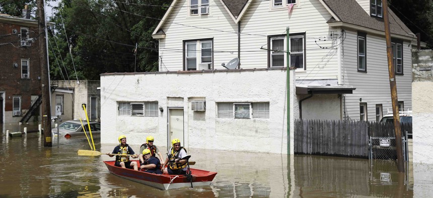 First responders make their way through floodwaters in Darby, Pa., Monday, Aug. 13, 2018. 