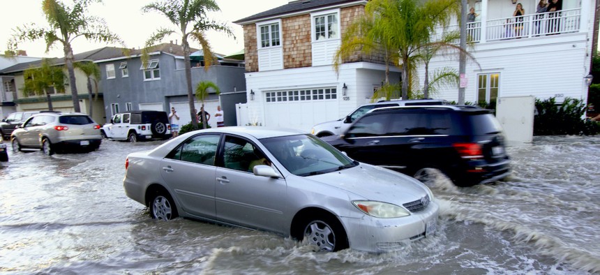 Vehicles drive through flooded streets in Newport Beach, Calif., Friday, July 3, 2020. California is one of the states most vulnerable to climate change and is ranked "more prepared" for its effects than other states in a new report.