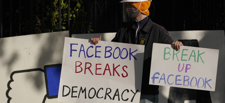 In this Saturday, Nov. 21, 2020, file photo, a demonstrator joins others outside of the home of Facebook CEO Mark Zuckerberg to protest what they say is Facebook spreading disinformation in San Francisco.