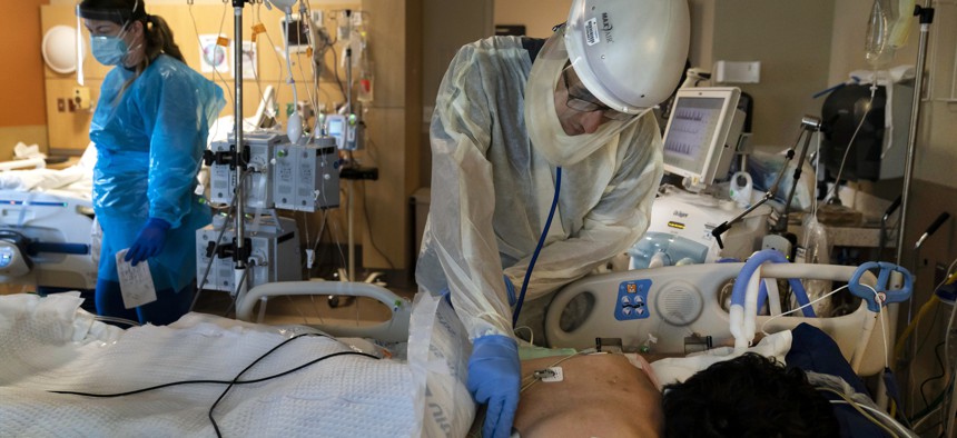 In this Nov. 19, 2020, file photo, Dr. Rafik Abdou checks on a COVID-19 patient at Providence Holy Cross Medical Center in the Mission Hills section of Los Angeles.