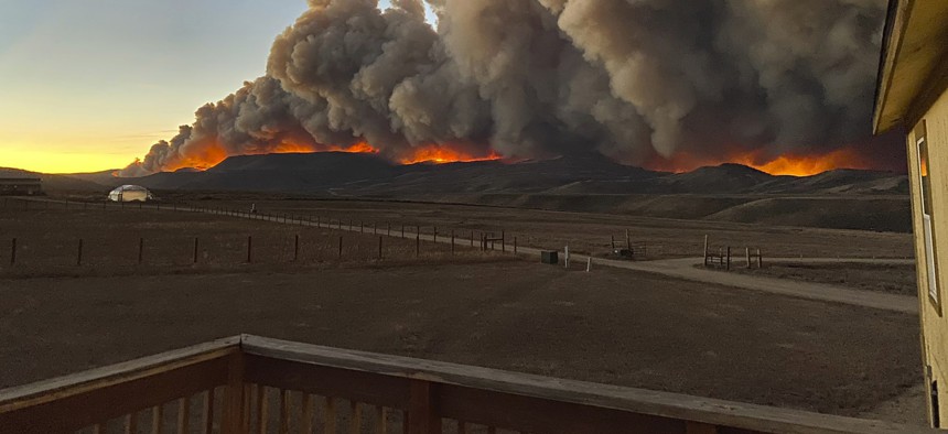 A resident took this photo from the deck of her home north of Granby, Colo., just before sunset on Wednesday, Oct. 21, 2020 as a wildfire burned in the distance.