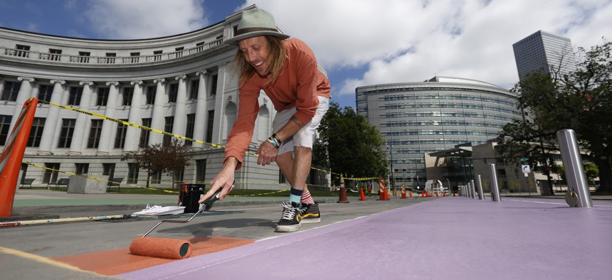 Artist Pat Milbery works to paint Denver's largest street mural on Bannock Street between Colfax Avenue and 14th Avenue in front of the City/County Building, Thursday, May 28, 2020.