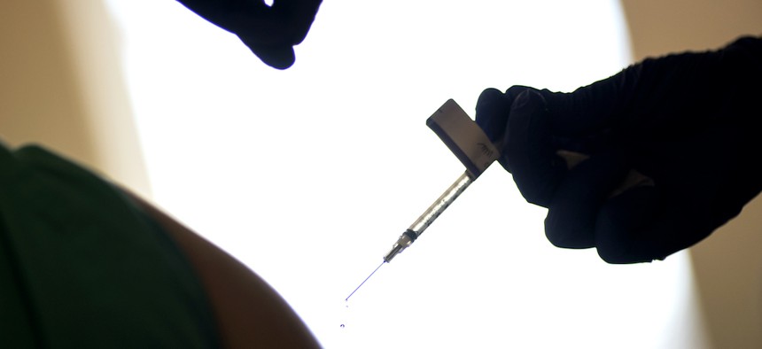 A droplet falls from a syringe after a health care worker was injected with the Pfizer-BioNTech COVID-19 vaccine at Women & Infants Hospital in Providence, R.I.