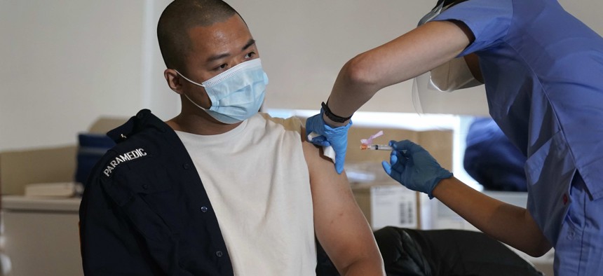 Medical personnel prepare a coronavirus vaccine against COVID-19 to be administered to New York City firefighter emergency medical services personnel at the FDNY Fire Academy in New York, Wednesday, Dec. 23, 2020.