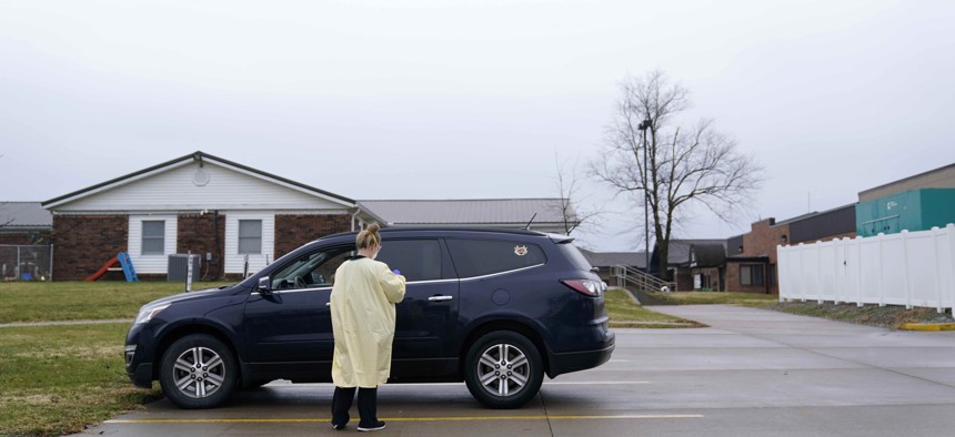 A registered nurse administers a Covid-19 test to a drive-up patient outside Scotland County Hospital Tuesday, Nov. 24, 2020, in Memphis, Mo. 