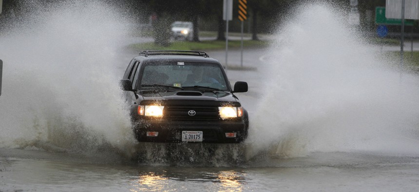 A car plows through a flooded street in the Ocean View area in Norfolk, VA., Sunday, Oct. 28, 2012. 