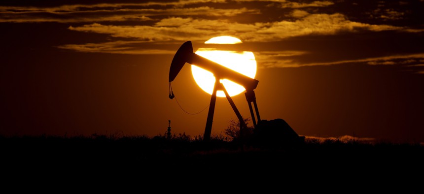 The sun sets behind an idle pump jack near Karnes City, Texas, during April 2020.