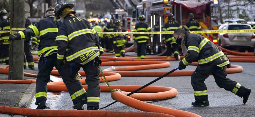 Firefighters work at the scene of a building fire in Englewood, N.J., on Dec. 2, 2020. Firefighters and other first responders are among the public workers unable to work remotely during the pandemic.