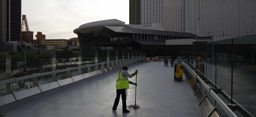 In this March 31, 2020, file photo, a worker cleans along the Las Vegas Strip devoid of the usual crowds when casinos and other business were shuttered due to the coronavirus outbreak in Las Vegas.
