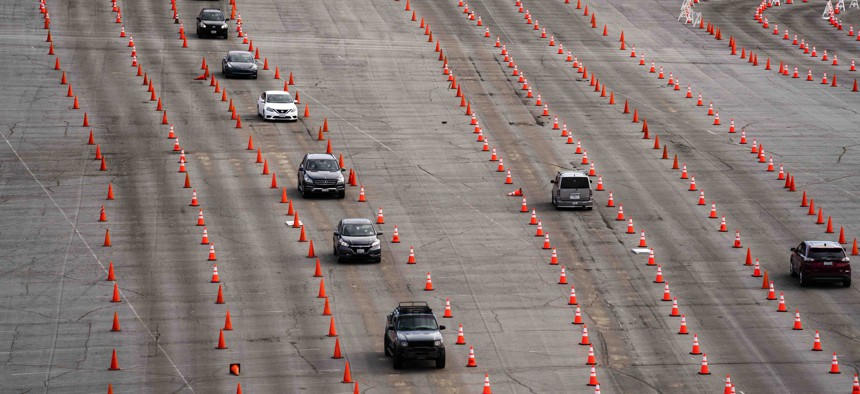 In this Feb. 1, 2021, file photo, light traffic flows through cones as people arrive at the Dodger Stadium parking lot to receive the COVID-19 vaccine in Los Angeles. 