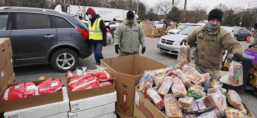 Sgt. Kevin Fowler organizes food at a food bank distribution by the Greater Cleveland Food Bank, Thursday, Jan. 7, 2021, in Cleveland.