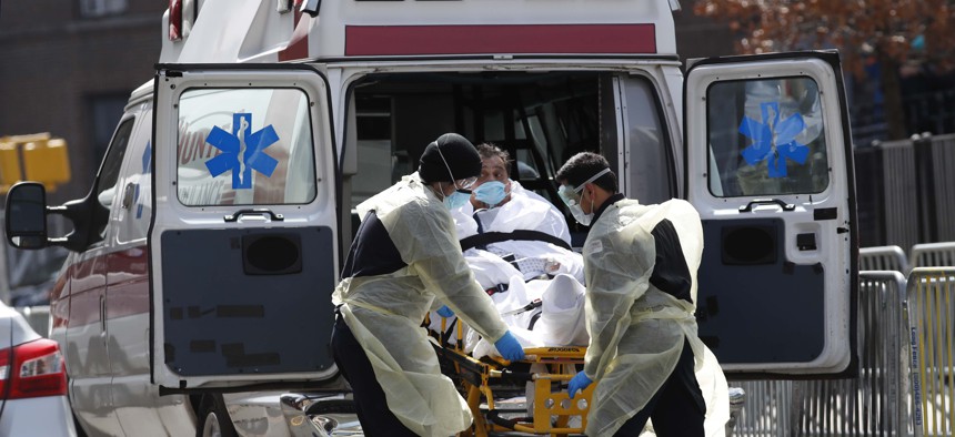 A patient is transferred into a waiting ambulance Elmhurst Hospital Center during the current coronavirus outbreak, Tuesday, April 7, 2020, in New York.