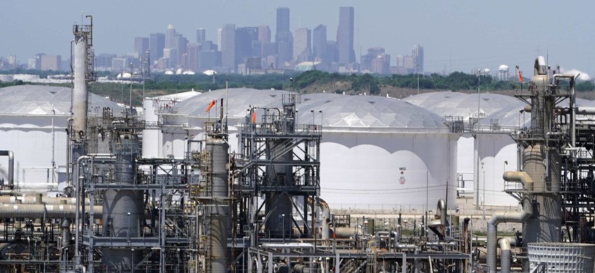 In this Thursday, April 30, 2020, photo storage tanks at a refinery along the Houston Ship Channel are seen with downtown Houston in the background. 