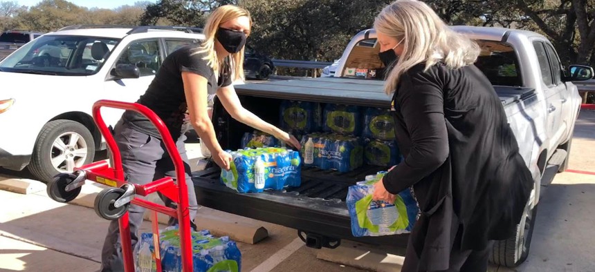 Austin City Council Member Paige Ellis, left, used her fiance's truck to distribute water to constituents during severe winter storms in Texas.