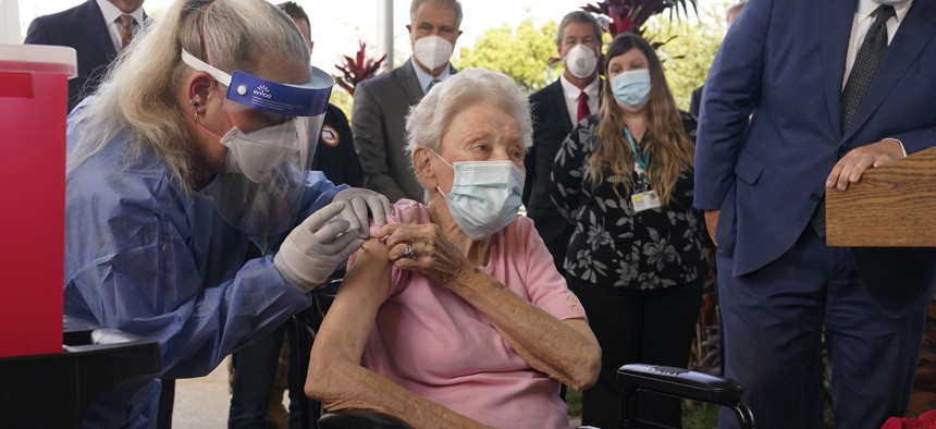 Nurse Christine Philips, left, administers the Pfizer vaccine to Vera Leip, 88, a resident of John Knox Village, Wednesday, Dec. 16, 2020, in Pompano Beach, Fla.
