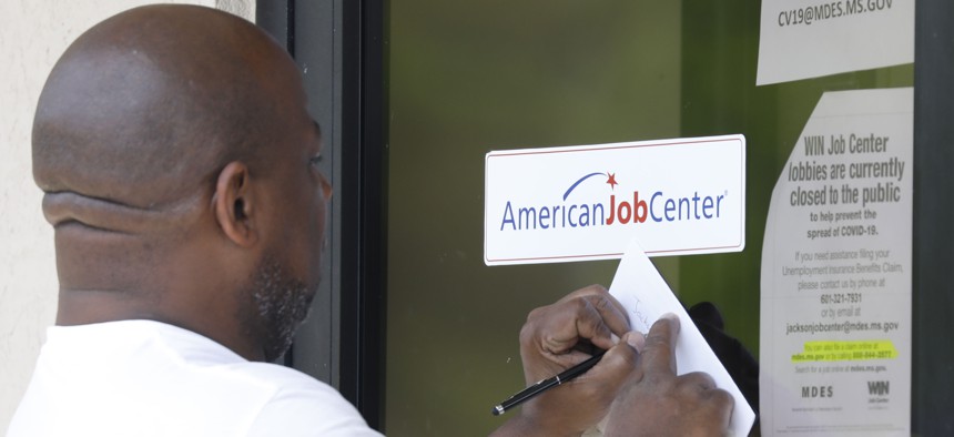 A resident copies down the Mississippi unemployment benefit website after being unable to enter the state WIN Job Center in north Jackson, Miss.