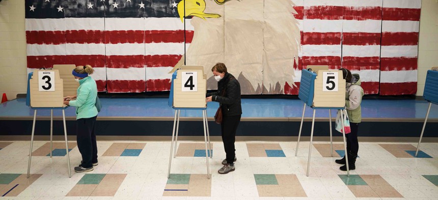 Voters cast their ballots under a giant mural at Robious Elementary school on Election Day, in Midlothian, Va., Tuesday Nov. 3, 2020.