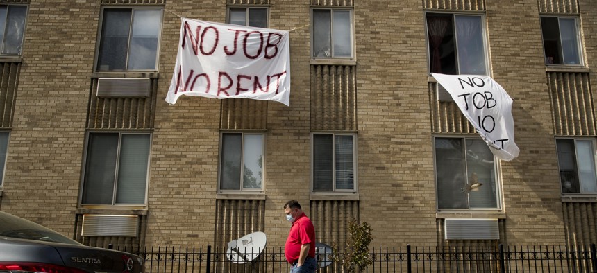 In this May 20, 2020, file photo, signs that read "No Job No Rent" hang from the windows of an apartment building during the coronavirus pandemic in Northwest Washington. 