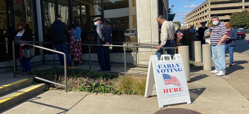Voters line up outside a polling place Wednesday, Oct. 21, 2020, in Charleston, W.Va.