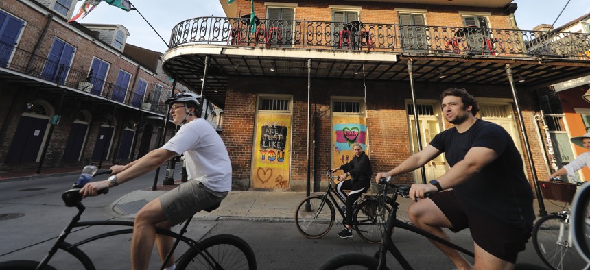 People ride bikes through the largely shuttered French Quarter of New Orleans, Tuesday, May 12, 2020. Attempts to curb the spread of COVID-19 have visited an economic whammy on the state as oil prices have plummeted and tourism has dried up.
