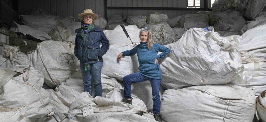 Gail, right, and Amy Hepworth, owners of Hepworth Farms, pose for a picture on bags full of hemp plants at Hepworth Farms in Milton, N.Y., Monday, April 12, 2021.