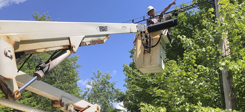 A Consolidated Communications technician works on a line used to provide broadband internet service in a rural area on Wednesday, July 29, 2020, in Stowe, Vt. Vermont officials are working to expand internet service using federal pandemic relief funds. 