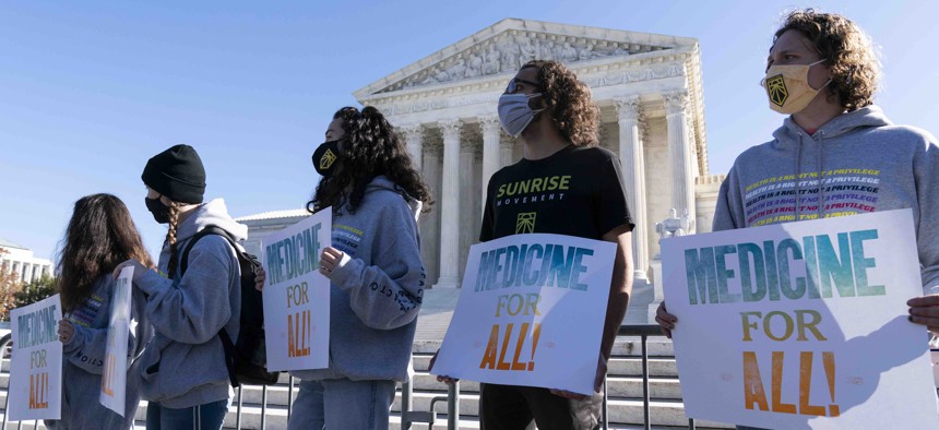 Demonstrators hold signs in front of the U.S. Supreme Court as arguments are heard about the Affordable Care Act Tuesday, Nov. 10, 2020, in Washington. 
