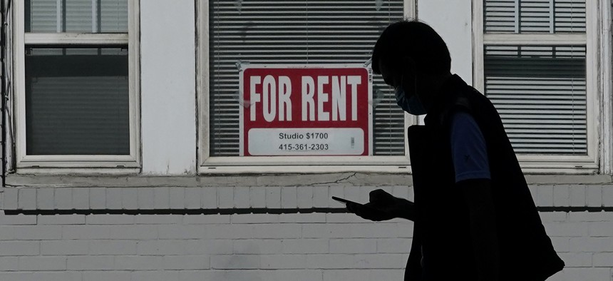 In this Oct. 20, 2020 file photo, a man walks in front of a For Rent sign in a window of a residential property in San Francisco. 