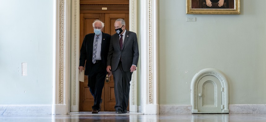 Sen. Bernie Sanders, I-Vt., left, and Senate Majority Leader Chuck Schumer of N.Y., right, walk out of a budget resolution meeting at the Capitol in Washington, Monday, Aug. 9, 2021. 