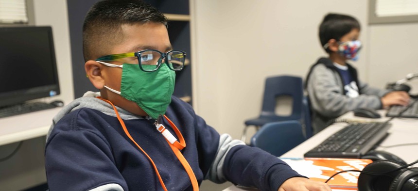 In this Dec. 3, 2020, file photo, students wearing face masks work on computers at Tibbals Elementary School in Murphy, Texas.
