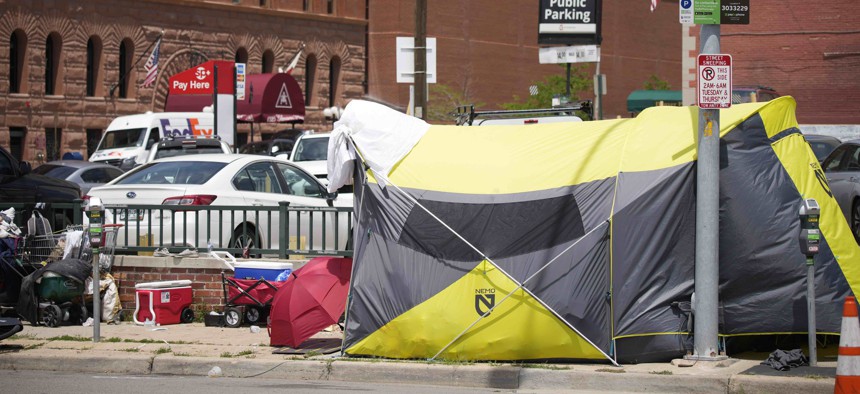 A tent put up by homeless individuals sits on a sidewalk Thursday, July 8, 2021, one block east of the Colorado Convention Center, the site of a major League Baseball promotion to mark the playing of the All Star Game in Denver. 