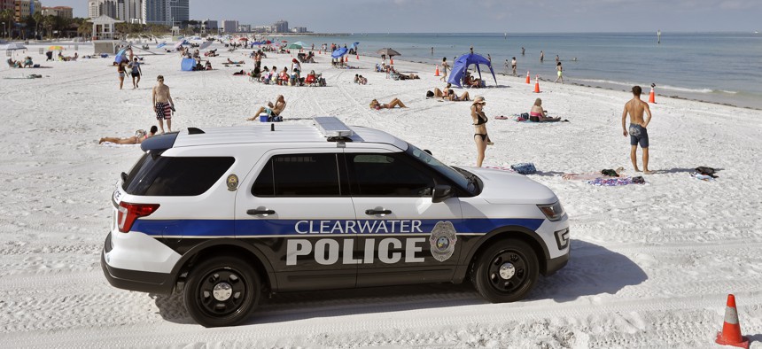 In this Monday, May 4, 2020 file photo, police officers patrol the area after Clearwater Beach officially reopened to the public in Clearwater Beach, Fla. 