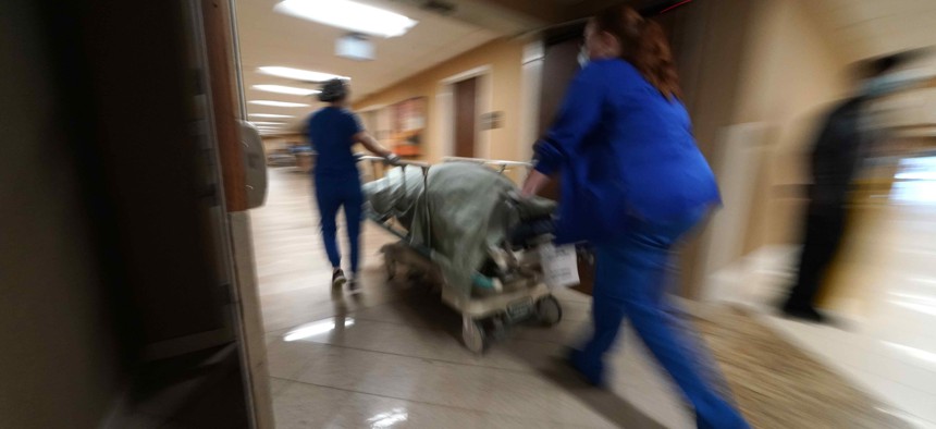 Medical staff move a COVID-19 patient who died to a loading dock to hand off to a funeral home van, at the Willis-Knighton Medical Center in Shreveport, La., Wednesday, Aug. 18, 2021. 