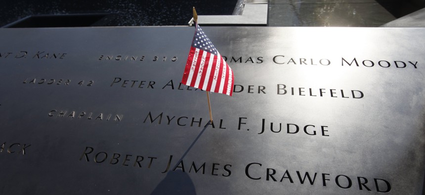 In this Monday, Sept. 12, 2011 file photo, a U.S. flag is stuck into the etched name of Father Mychal F. Judge, the New York Fire Department chaplain who died in the 9/11 attacks on the World Trade Center, at the National September 11 Memorial in New York.