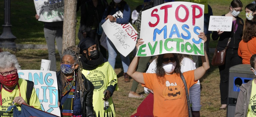 Protesters display placards while calling for support for tenants and homeowners at risk of eviction during a demonstration, Sunday, Oct. 11, 2020, on the Boston Common, in Boston, as the state weathers the ongoing COVID-19 crisis. 