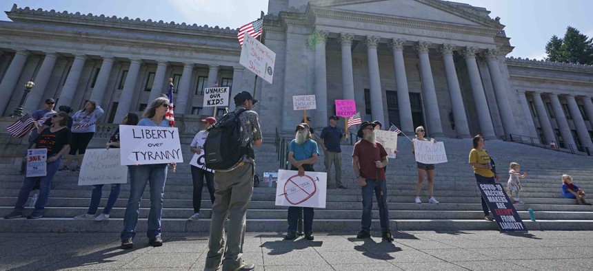 Protesters who oppose mask and COVID-19 vaccine mandates gather outside the Legislative Building, Wednesday, Aug. 18, 2021, at the Capitol in Olympia, Wash.