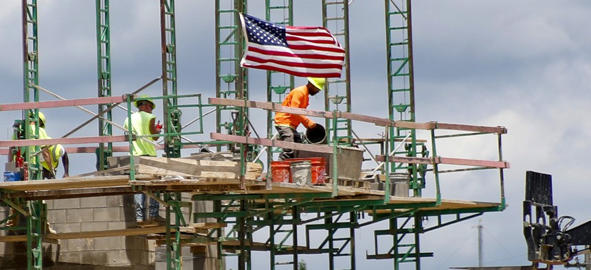 Workers on scaffolding lay blocks on one of the larger buildings at a development site where various residential units and commercial sites are under construction, Thursday, June 11, 2020, in Cranberry Township, Butler County, Pa.
