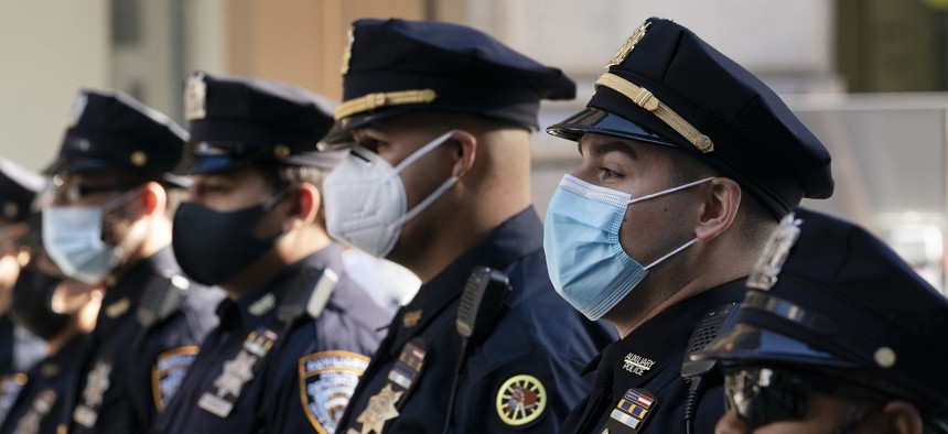 In this Oct. 5, 2020, file photo, New York Police Department officers in masks stand during a service at St. Patrick's Cathedral in New York to honor 46 colleagues who have died due to COVID-19 related illness. 