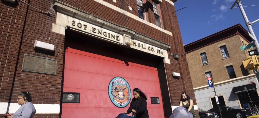 Pedestrians walk past FDNY Firehouse, Engine 307, Ladder 154 on Monday, Nov. 1, 2021, in New York. About 9,000 New York City municipal workers were put on unpaid leave for refusing to comply with a COVID-19 vaccine mandate that took effect Monday and thousands of city firefighters have called out sick in an apparent protest over the requirement. 