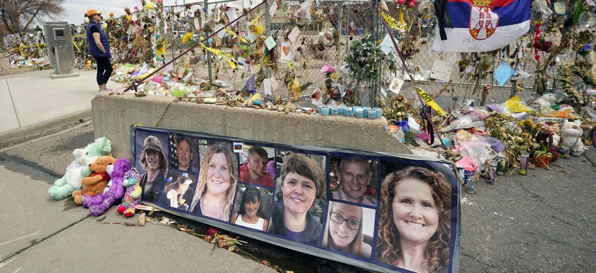 In this April 23, 2021, file photo, photographs of the 10 victims of a mass shooting in a King Soopers grocery store are posted on a cement barrier outside the supermarket in Boulder, Colo. 