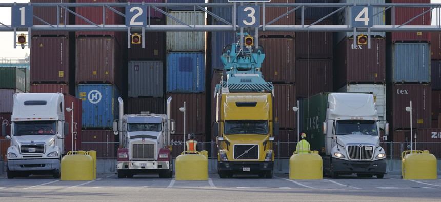 Trucks line up to have containers loaded from a stack at the Norfolk International Terminal Wednesday Dec 1, 2021, in Norfolk, Va.